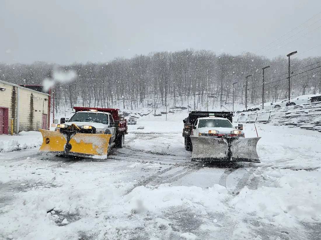 Multiple commercial snow plow trucks working during snowfall in Lackawanna County Pennsylvania