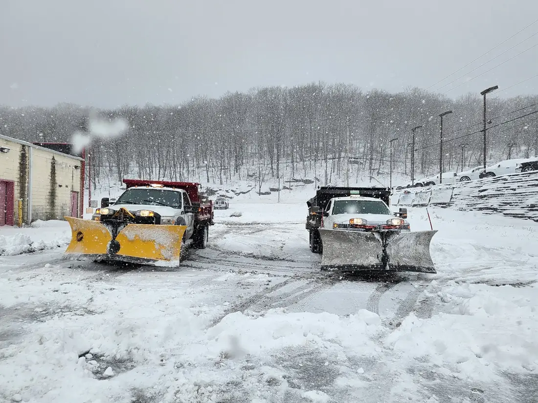 Multiple commercial snow plow trucks operating during snowfall in Lackawanna County Pennsylvania